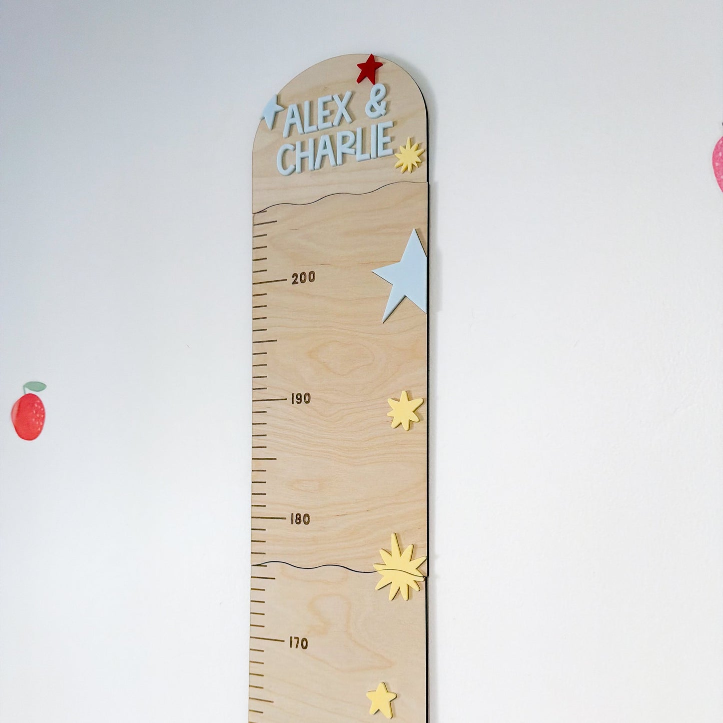 Wooden growth chart with decorative elements on a white background