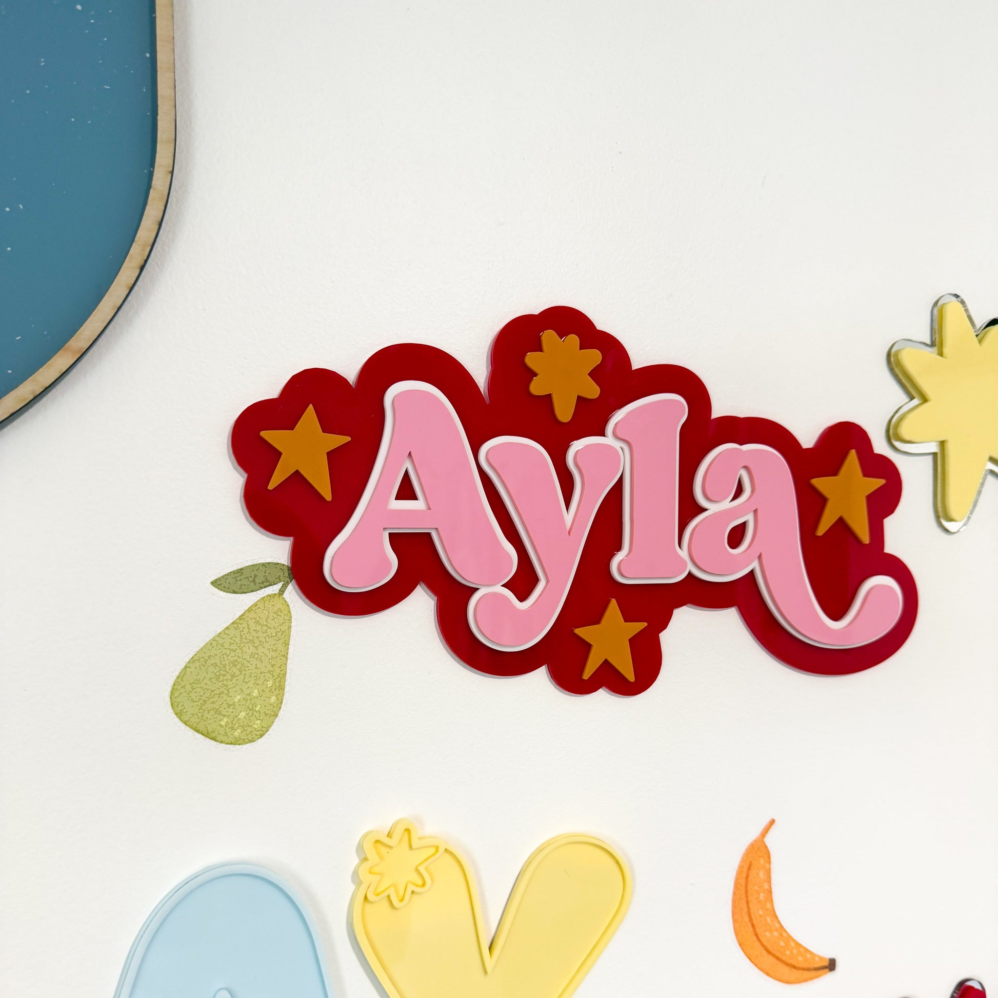 Colorful decorative letters spelling 'Ayla' with star and moon shapes on a white background