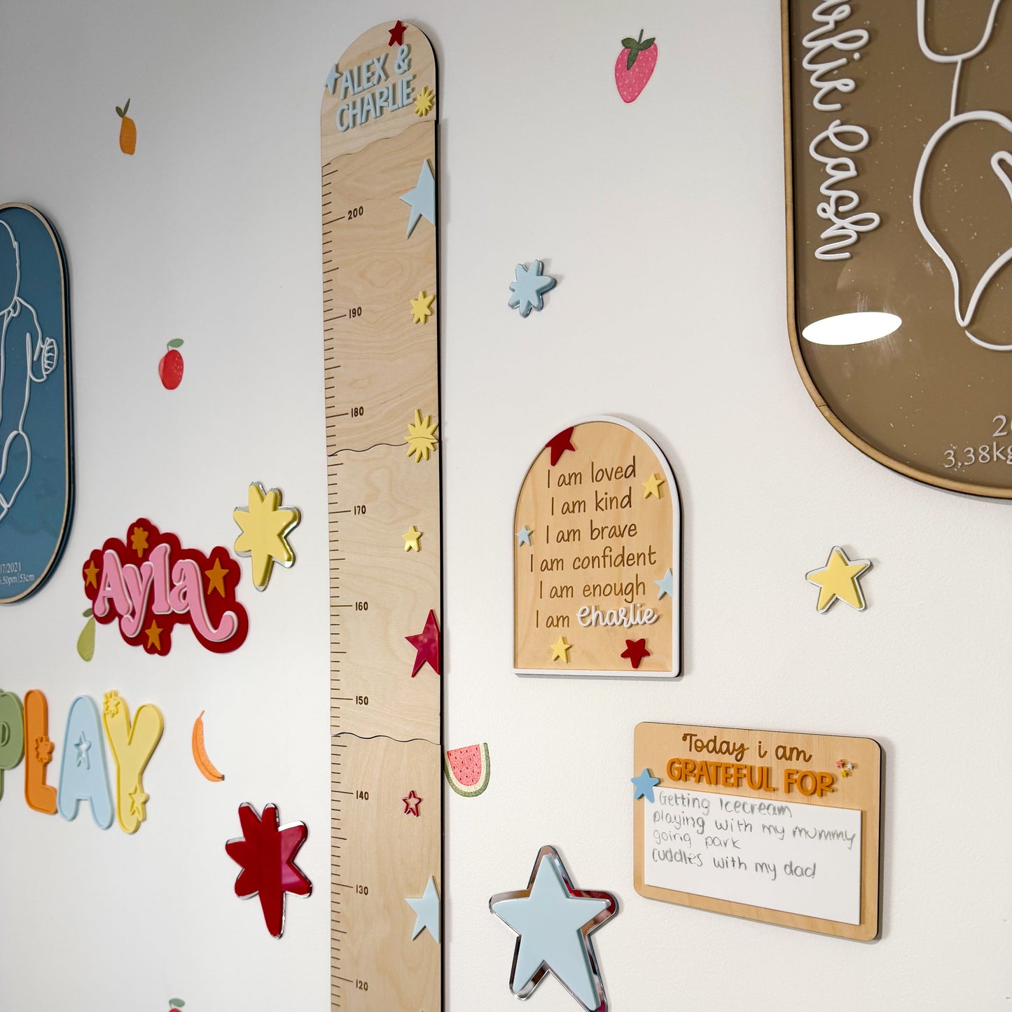 Children's growth chart with motivational phrases and colorful decorations on a wall.