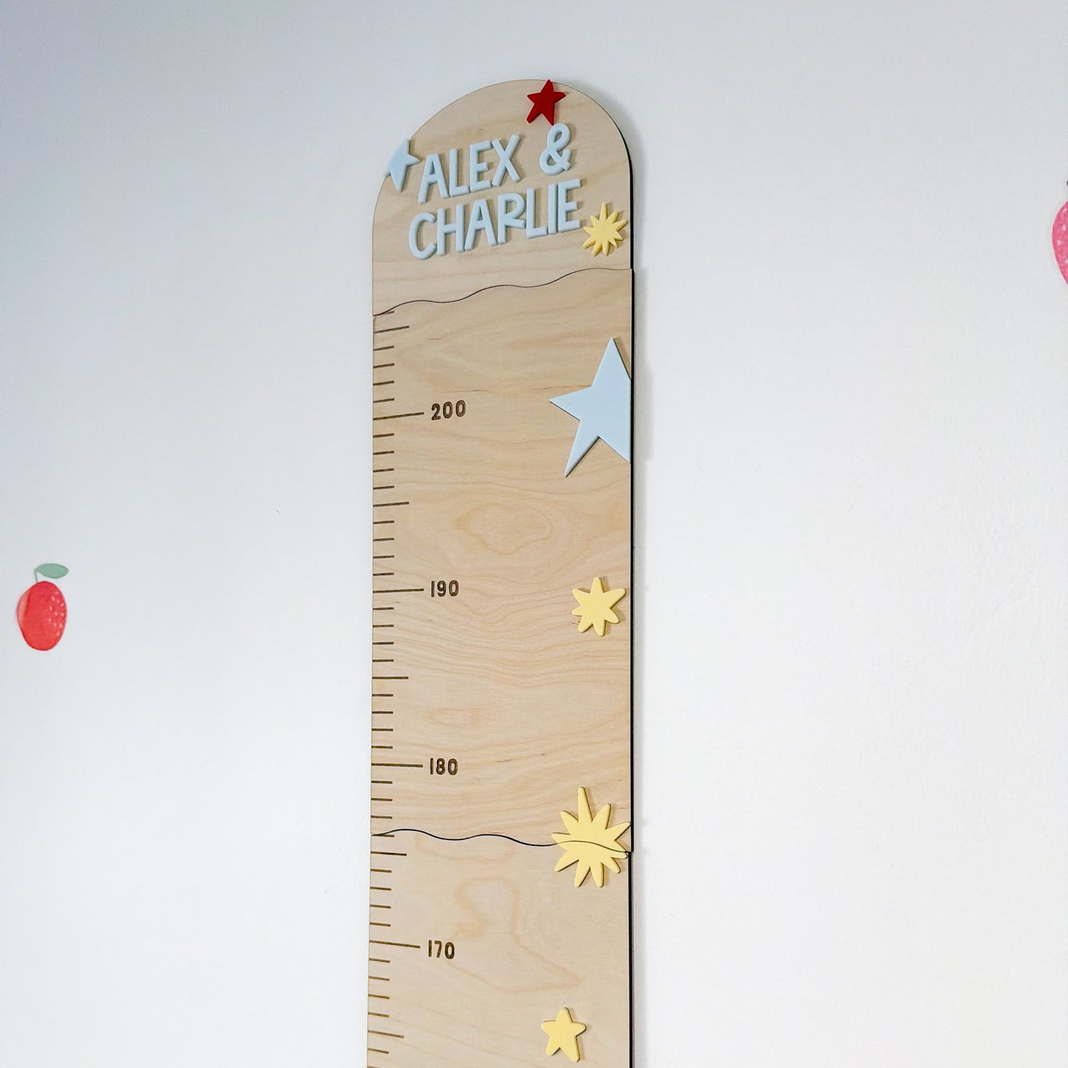 Wooden growth chart with decorative elements on a white background