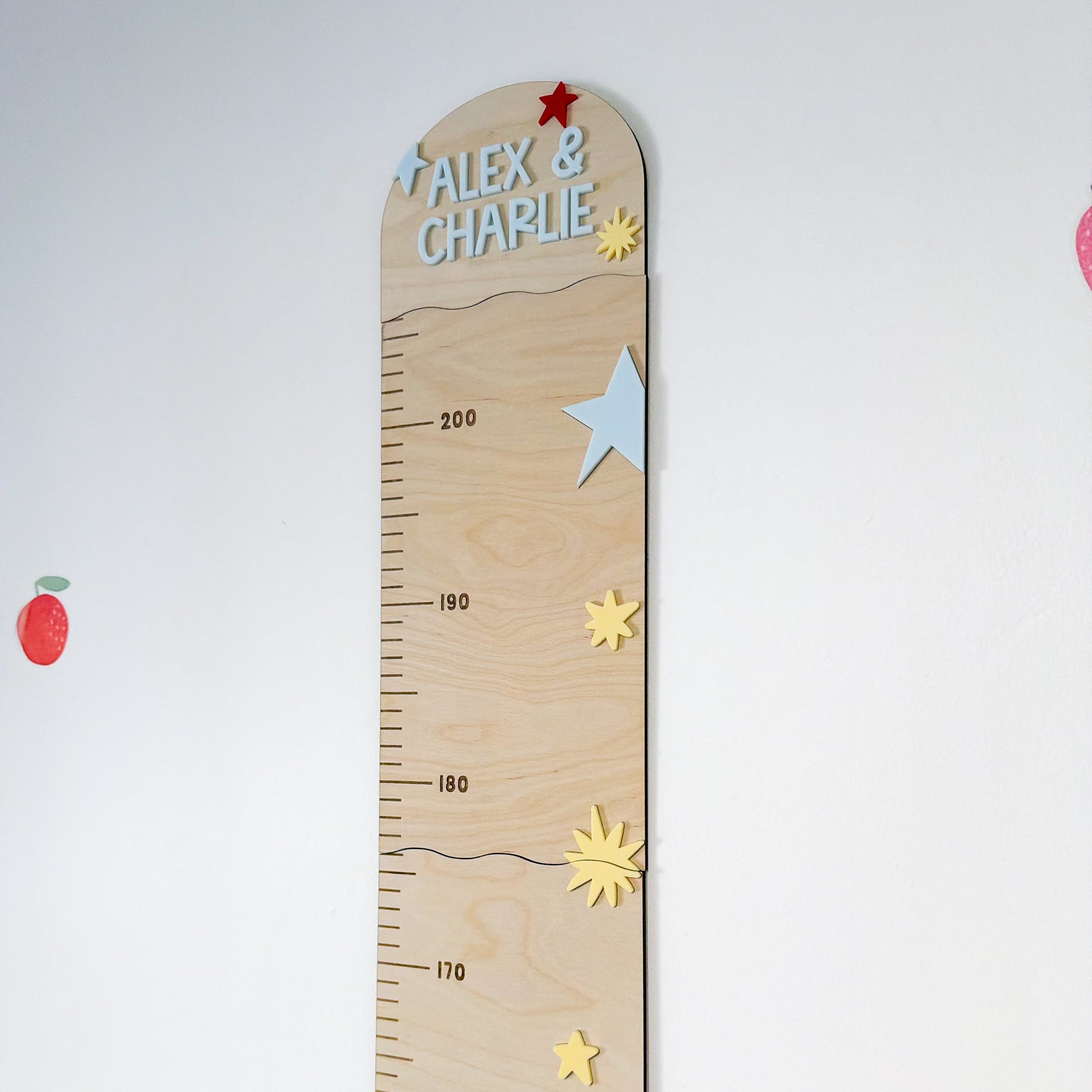 Wooden growth chart with decorative elements on a white background