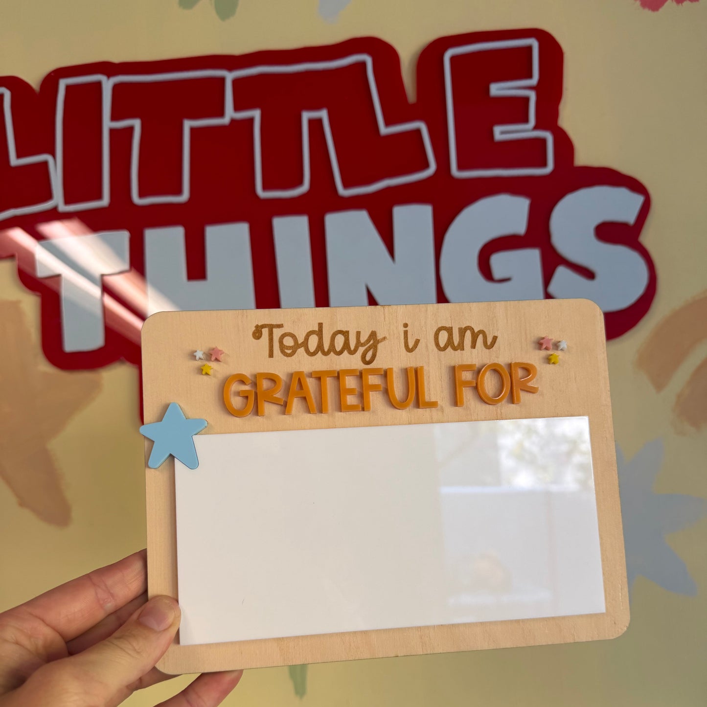 Hand holding a card with 'Today I am grateful for' text against a colorful background